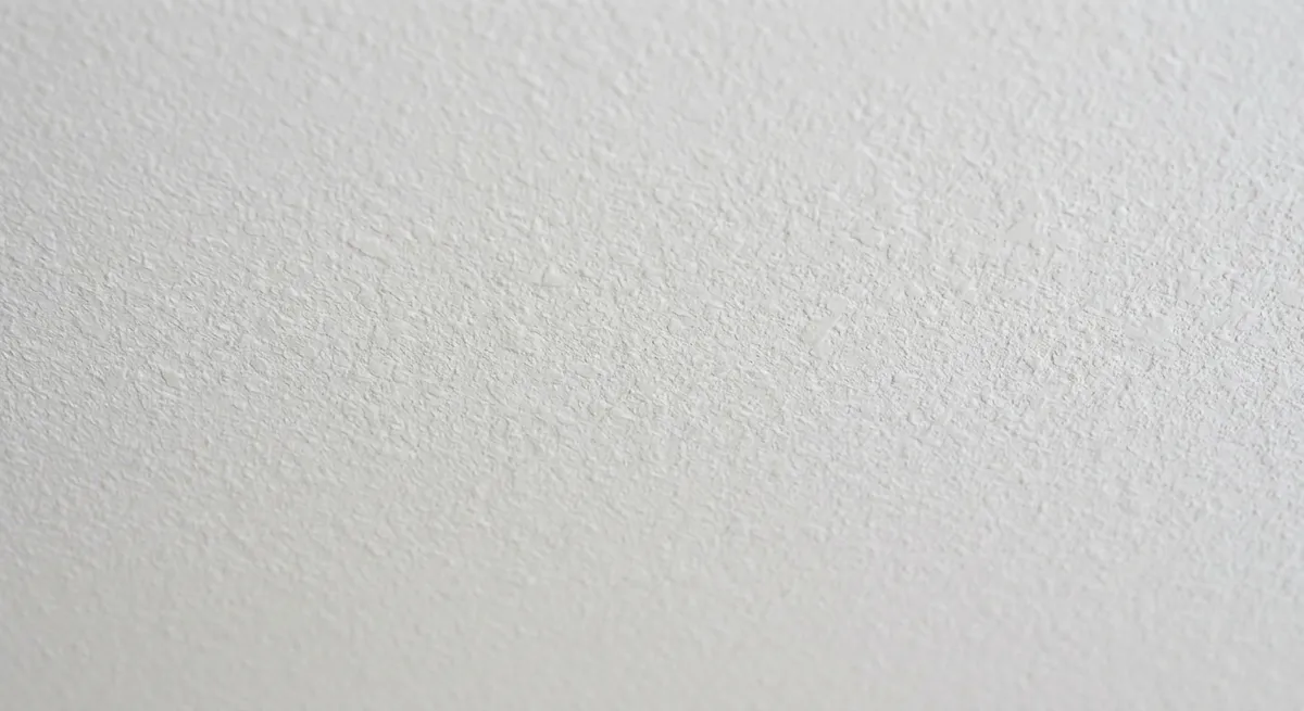 Pintor igualando la textura de un techo interior en el área reparada